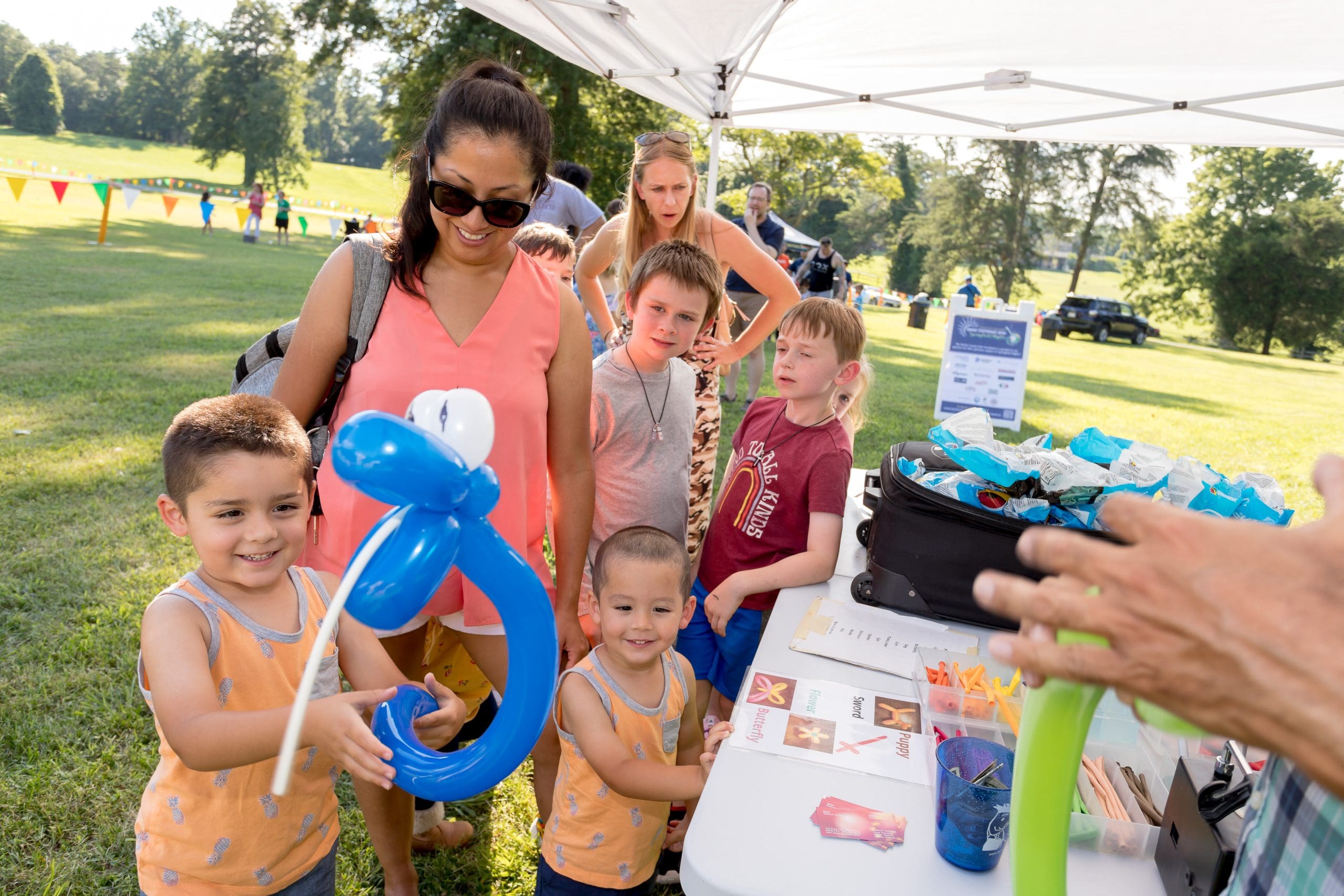 Balloon twisting at Springfield Nights with children and adults waiting in line.