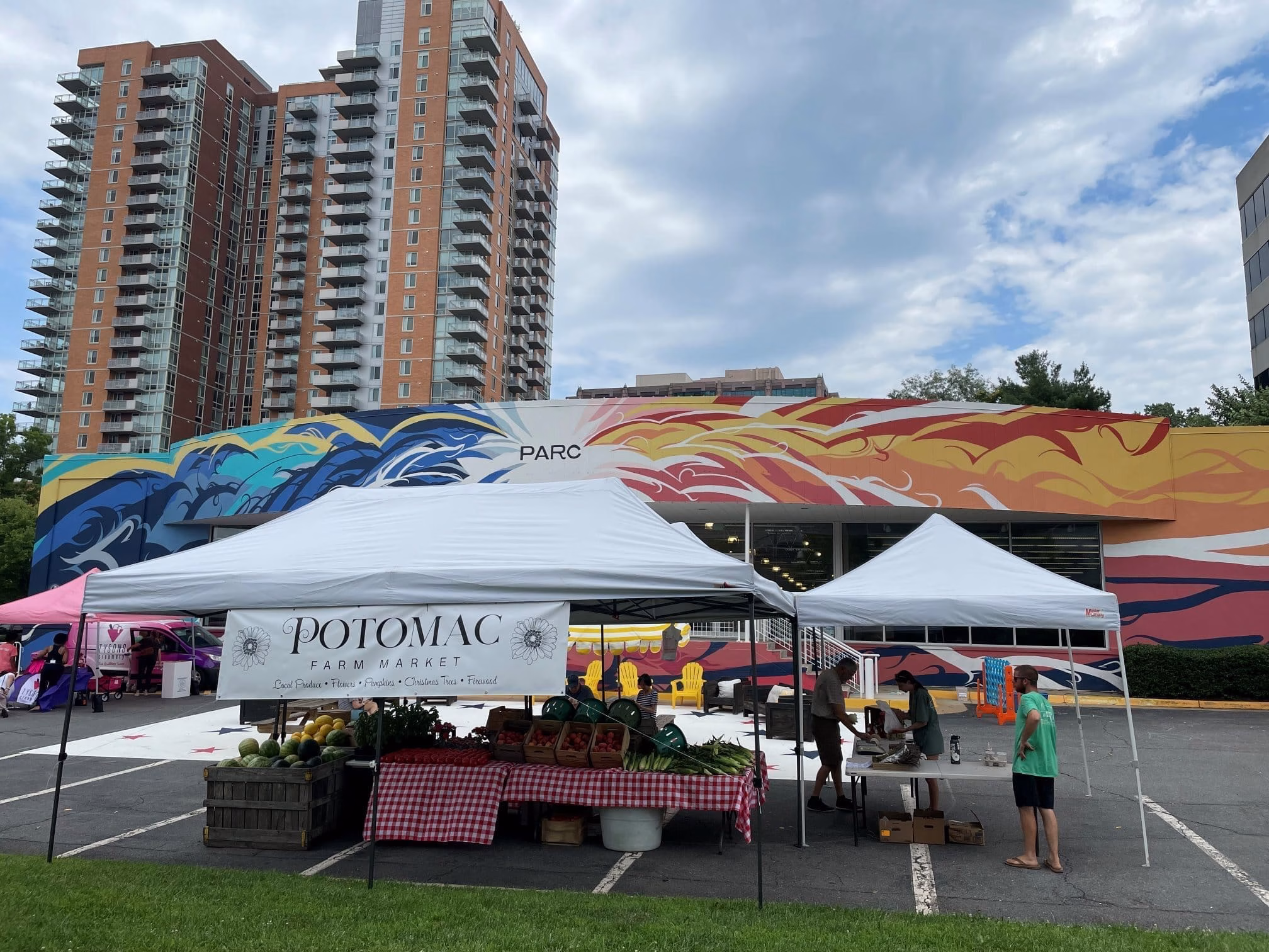 A vibrant farmers' market in an urban environment, showcasing fresh produce and local goods.