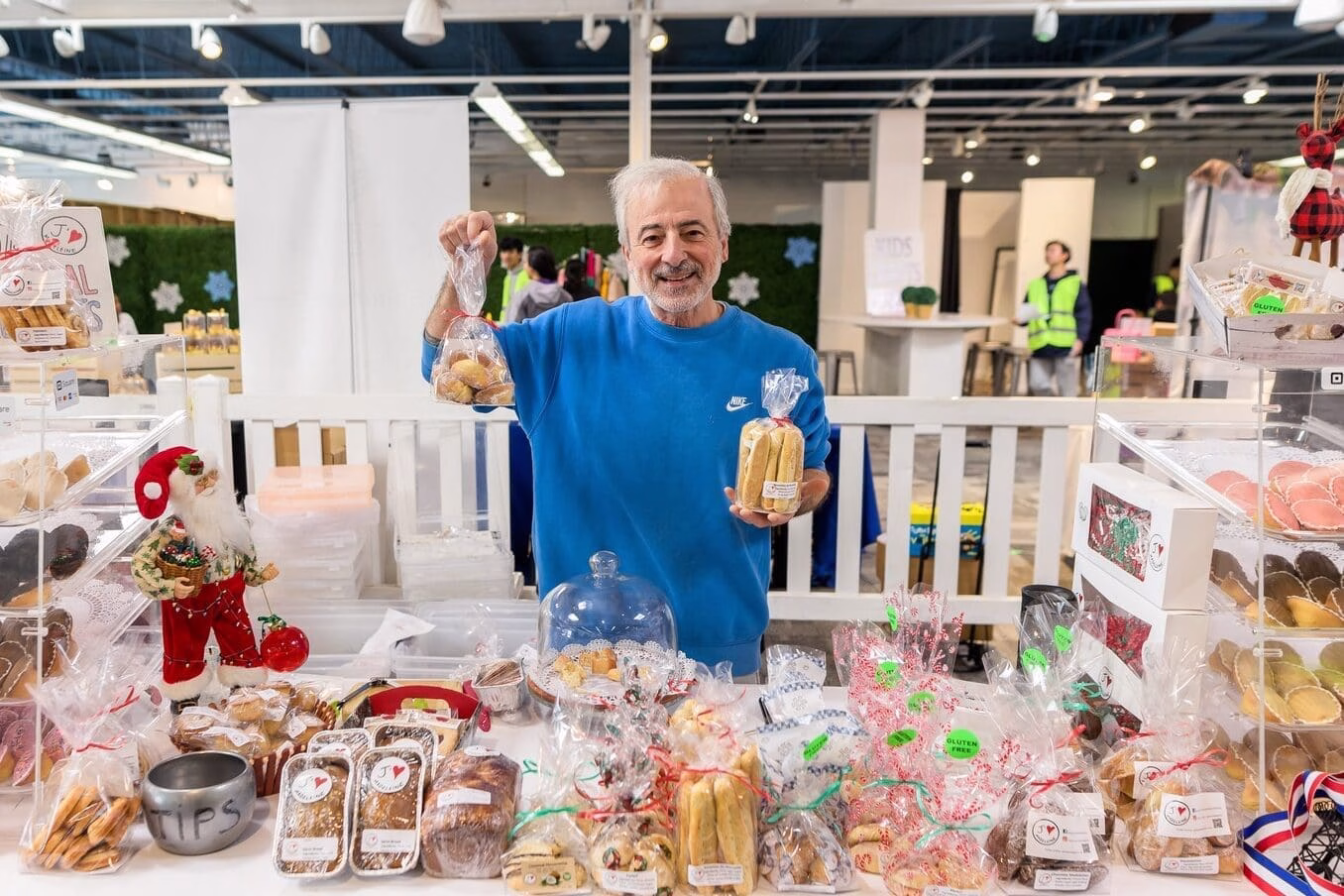 Man standing behind a table of baked goods