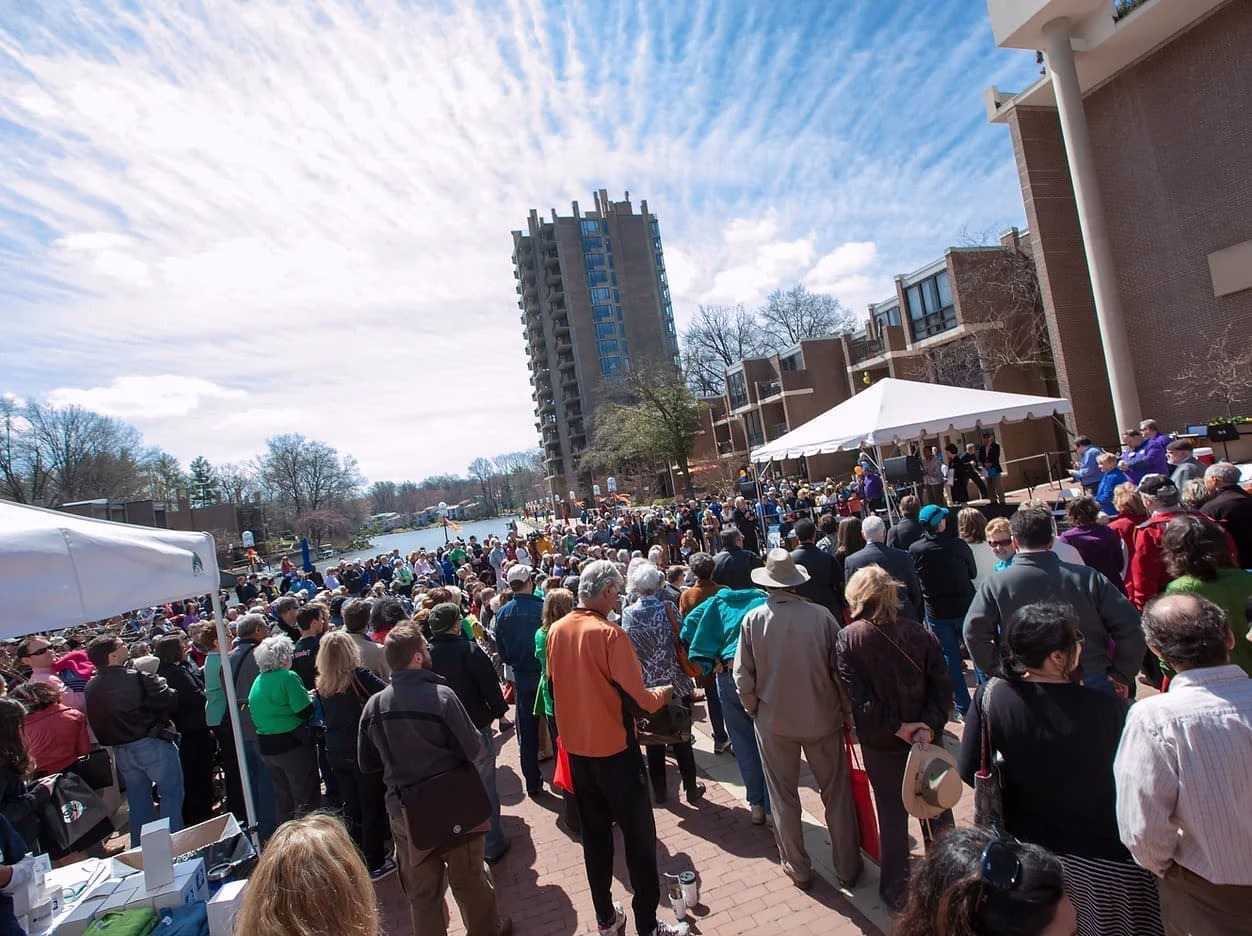 A large crowd of people gathered outside on a sunny day