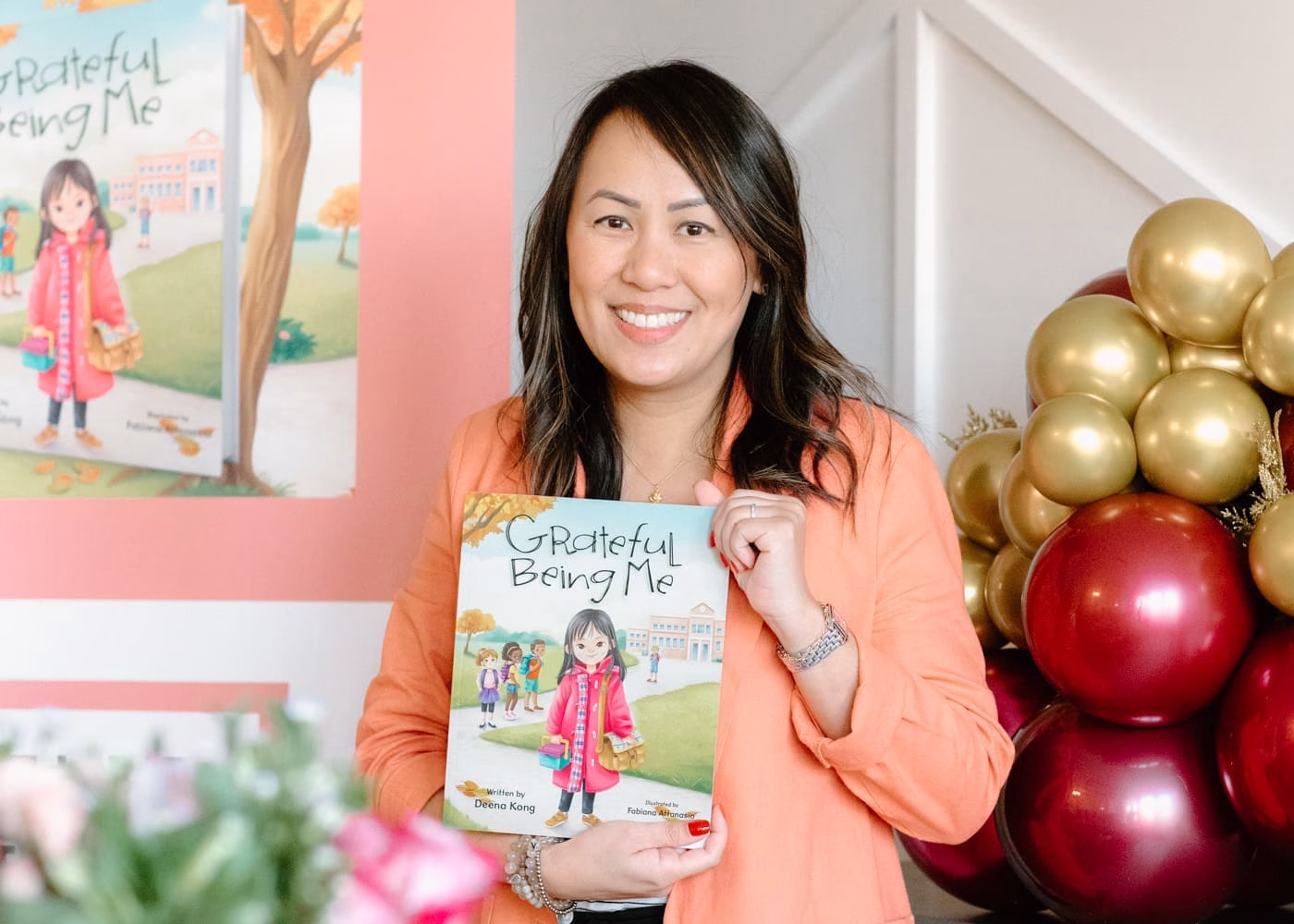 A woman holding a children's book titled Grateful Being Me
