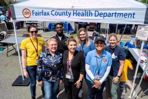 Fairfax County Health Department event with people standing under a tent