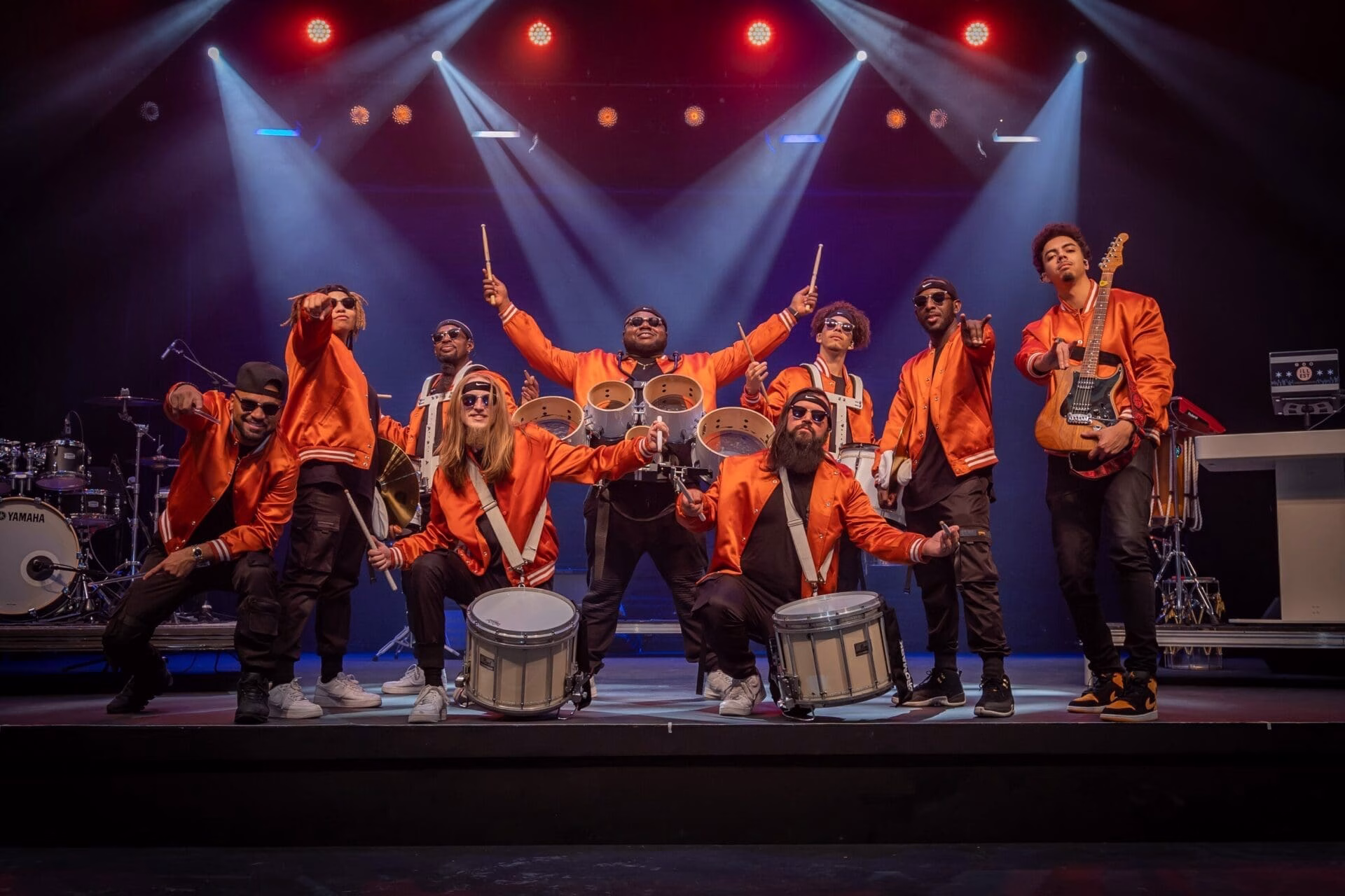 A group of musicians performing on stage, with a focus on their energetic and dynamic performance.