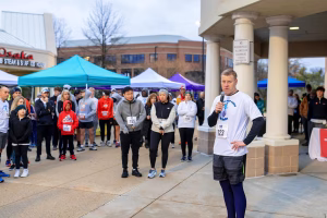A man speaking to a crowd at a running event