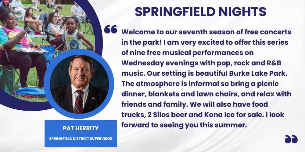 A group of people sitting in a park, enjoying a picnic and watching a concert