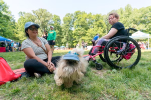 Two women and a dog sitting in a park on a sunny day