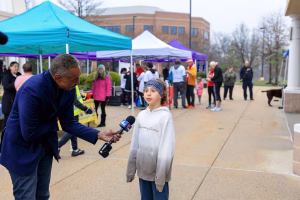 A young boy is being interviewed by a news reporter.