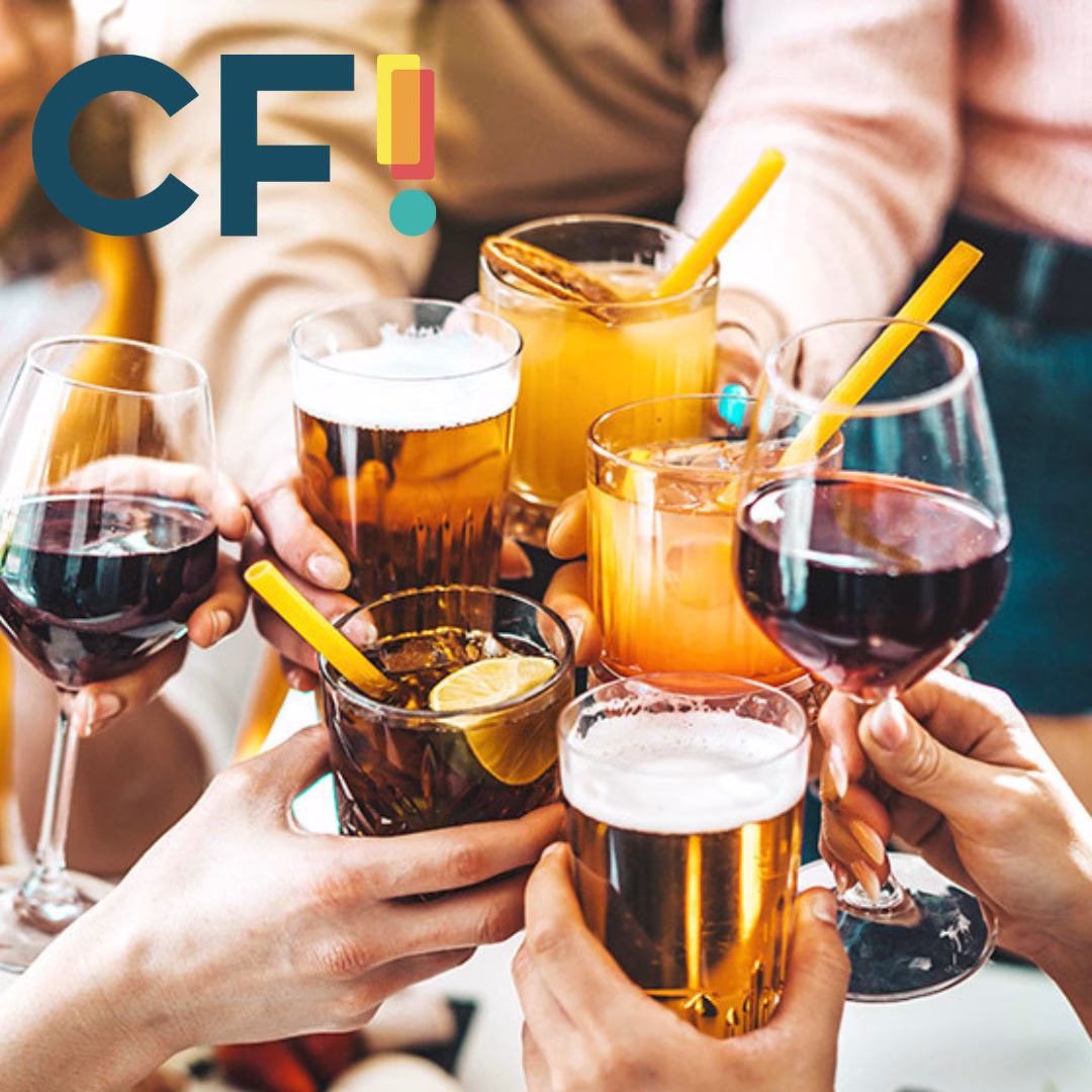 A group of people clinking their glasses together in a toast, with a variety of drinks and snacks around them.