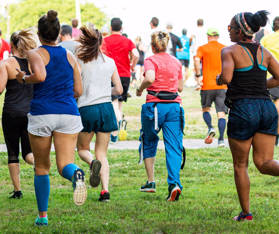 A group of people running in the park on a sunny day, enjoying outdoor exercise and fresh air.