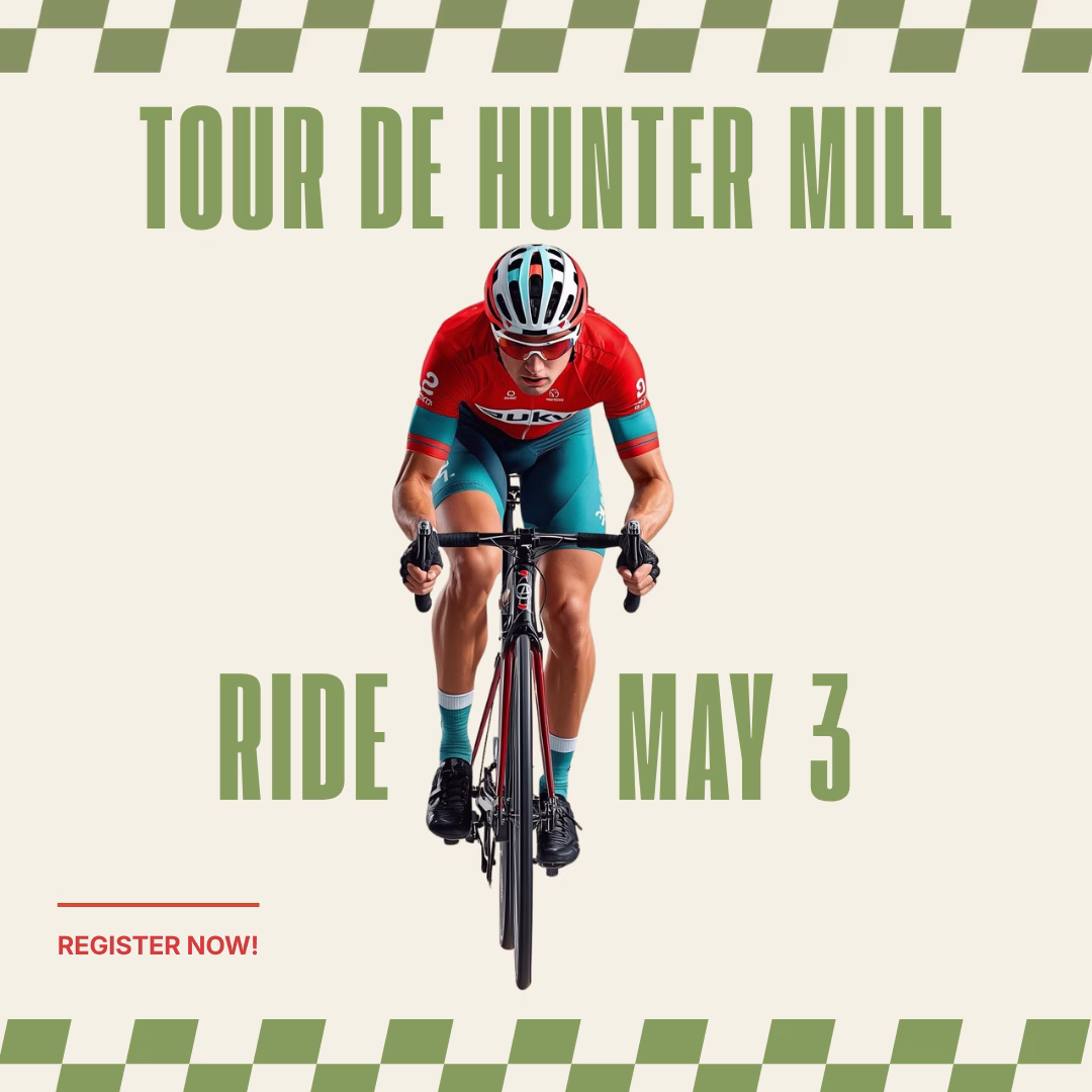 A man riding a bicycle with a red jersey and blue shorts