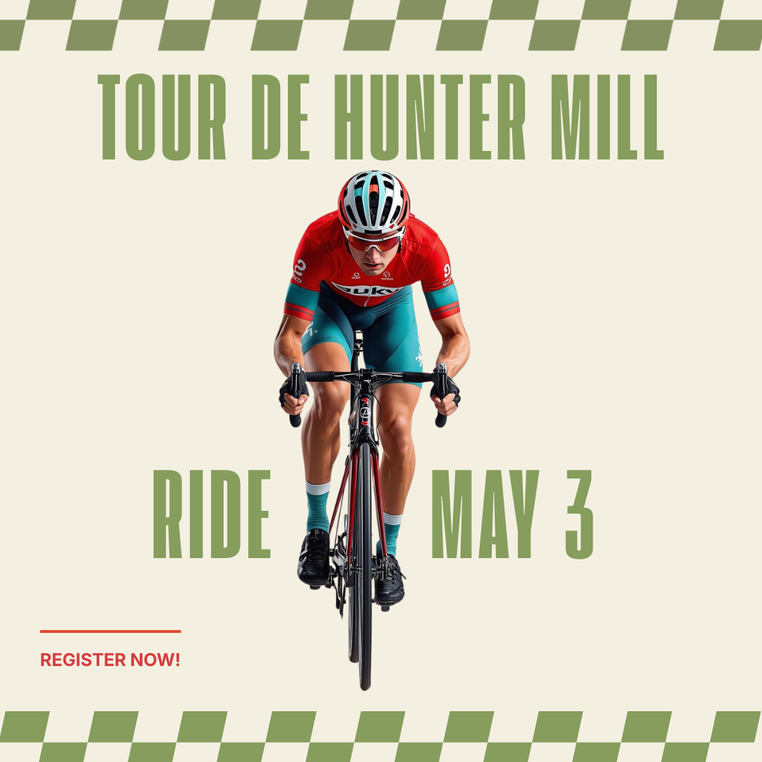 A man riding a bicycle with a red jersey and blue shorts