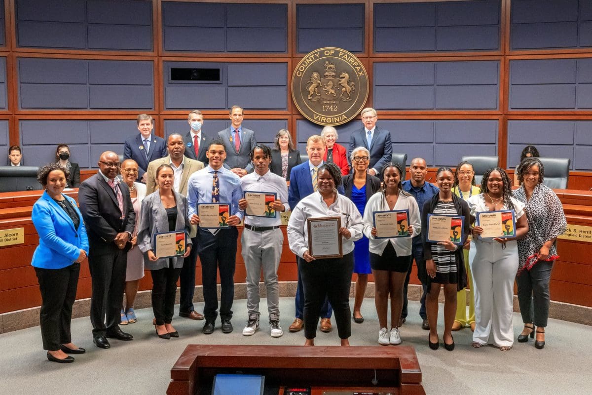 Group shot of award winners and Board of Supervisors in front of dais.